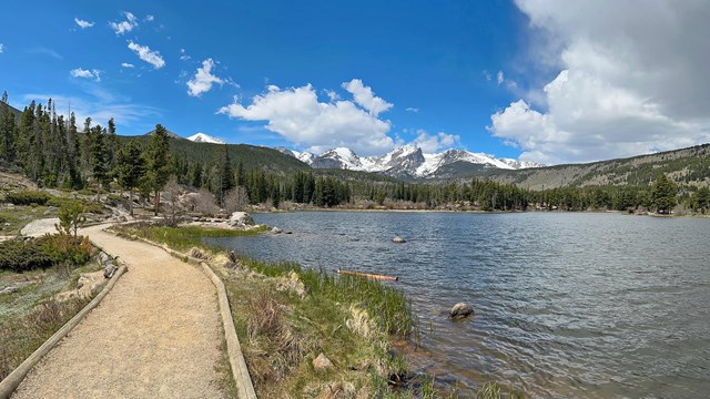 A trail along a lake is clear and dry on a sunny day